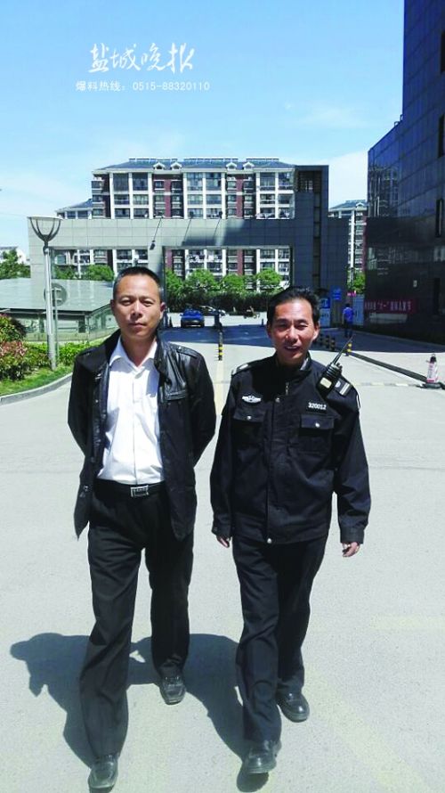 物管员黄辉和罗文乾在小区里巡逻.