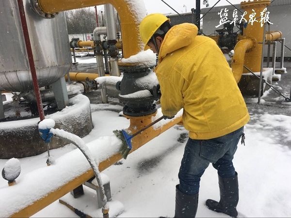 图为燃气工人正在扫除燃气管道上的积雪,保证燃气管道能够正常运行.