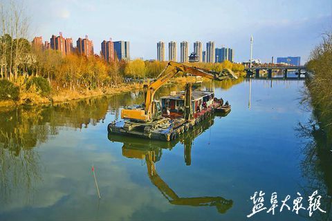 4月26日,在市区水街附近的串场河河面上,工人正在清理杂物和淤泥.