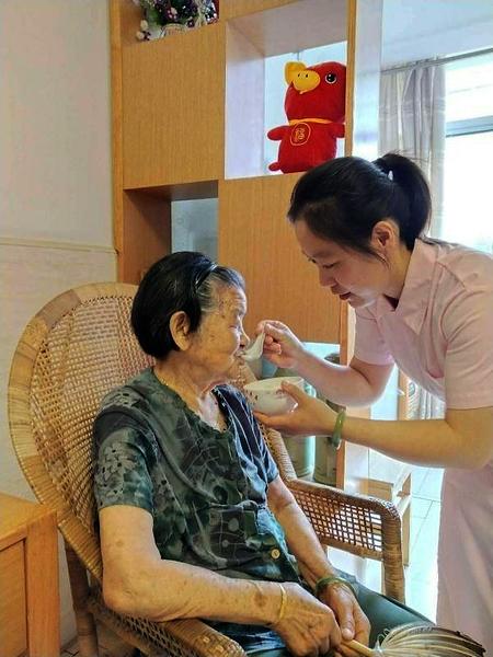 朱志娥在给老人喂饭.